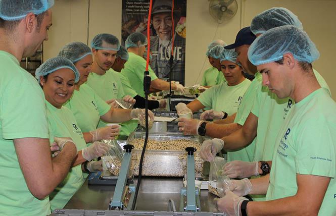 Volunteers from Recology portion beans into smaller quantities for individual clients in Project Open Hand's warehouse. Photo: Marcus Tolero, Project Open Hand<br>