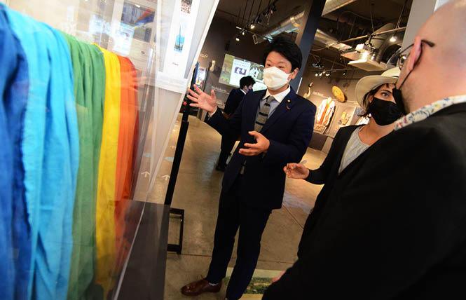 Taiga Ishikawa, the only out member of the Japanese legislature, looks at a piece of the original rainbow flag during his tour of the GLBT History Museum. Photo: Rick Gerharter
