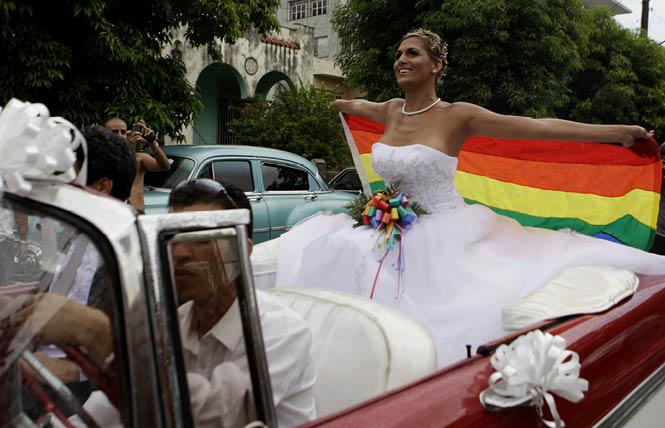Wendy Iriepa, a transsexual woman, wears her wedding dress and holds a rainbow flag while riding in a classic car in Havana, Cuba, on December 18, 2018, after the last attempt to legalize same-sex marriage in the Caribbean Island nation's new constitution was defeated. Photo: AP/Javier Galeano<br>