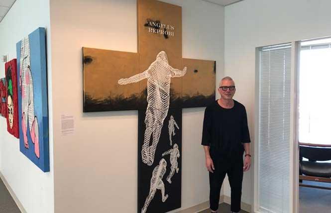 Joseph Abbati stood next to his artwork in state Senator Scott Wiener's San Francisco office in 2019; he continues to curate the legislator's art shows with KT Siebert. Photo: Matthew S. Bajko<br><br>