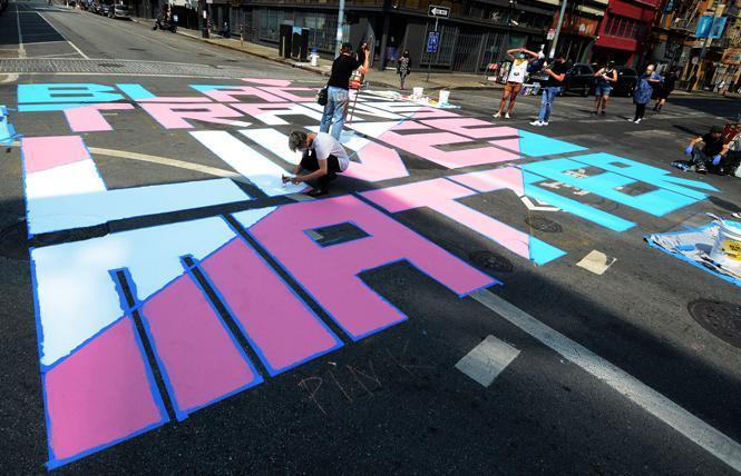 Volunteers put the finishing touches on a Black Trans Lives Matter mural at the corner of Turk and Taylor streets in August 2020. Photo: Rick Gerharter