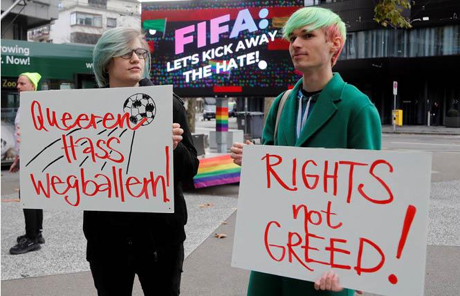 With Qatar set to host the 2022 World Cup, participants display placards as LGBTQ+ associations protest in front of the FIFA World Football Museum in Zurich, Switzerland November 8, 2022. Photo: Courtesy Reuters/Arnd Wiegmann