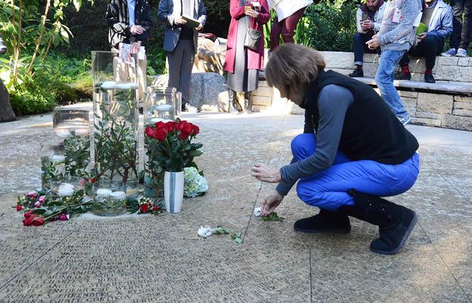 Cathy Jefferson placed a flower on the name of her brother in the Circle of Friends as part of the December 1, 2016 World AIDS Day remembrance in the National AIDS Memorial Grove in Golden Gate Park. Photo: Rick Gerharter