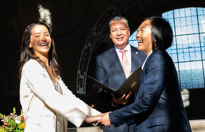 Tessa Chavez, left, and Cyn Wang smile after renewing their vows in a December 2 ceremony officiated by U.S. Senator Alex Padilla at San Francisco City Hall. Photo: Christopher Robledo