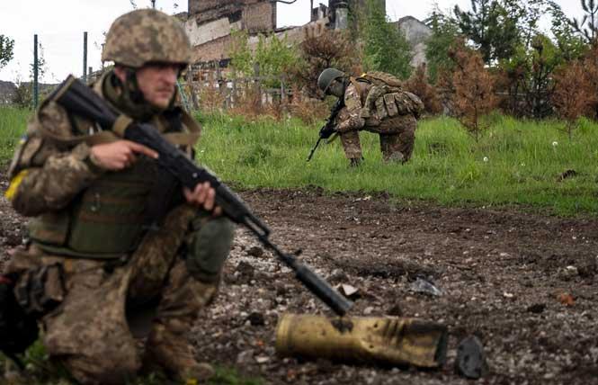Ukrainian soldiers squat during a patrol in a recently retaken village north of Kharkiv in Ukraine on May 15. Photo: Mstyslav Chernov/AP file