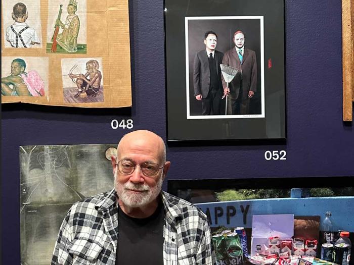 Gay photographer Mark Chester's stands in front of his take on Grant Wood's classic painting "American Gothic," now on exhibit at the de Young Museum that features two gay men of color in whiteface. Photo: Courtesy Mark Chester