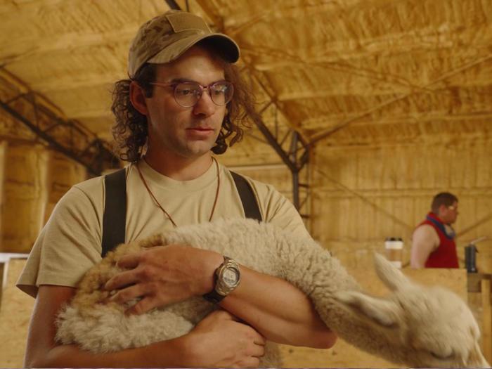 J Stanley holds a young alpaca in 'We Are Tenacious' (photo: Silent Crow Arts)