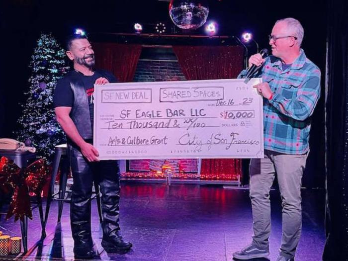 SF Eagle Bar owner Lex Montiel, left, accepts a $10,000 grant from SF New Deal Executive Director Simon Bertrang during a December 16 ceremony. Photo: Omar Morales