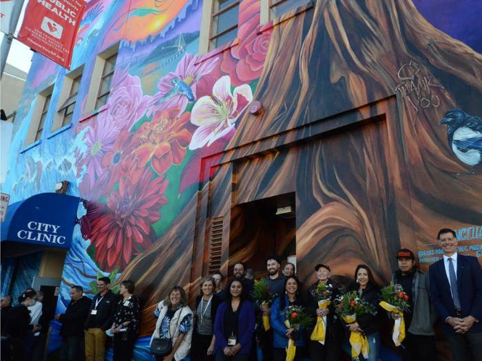 Staff from City Clinic, muralists, and others from the Department of Public Health celebrated the dedication of a new mural, "Sanctuary for Health," on the facade of the clinic's building in November 2022. Considered dilapidated by city officials, the health facility could be relocated using funds from a planned bond measure under review. Photo: Rick Gerharter